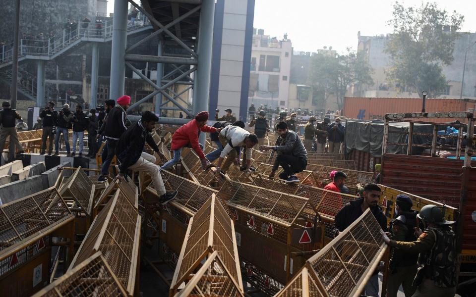 Protesting farmers jump police barricades tp march to the capital - Altaf Qadri /AP