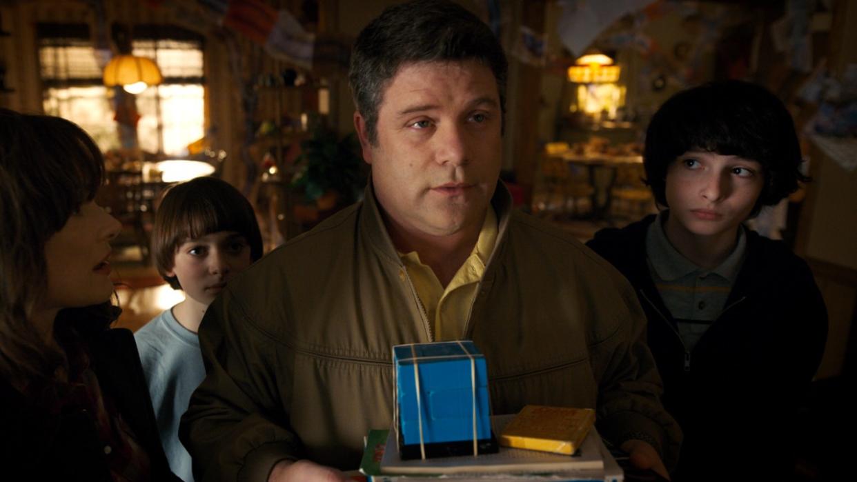  A press photo of Sean Astin as Bob in Stranger Things holding a blue box. . 