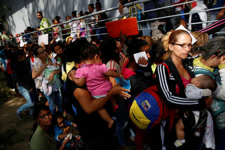 Women carrying babies queue as they try to buy diapers outside a pharmacy in Caracas, Venezuela March 18, 2017. REUTERS/Carlos Garcia Rawlins