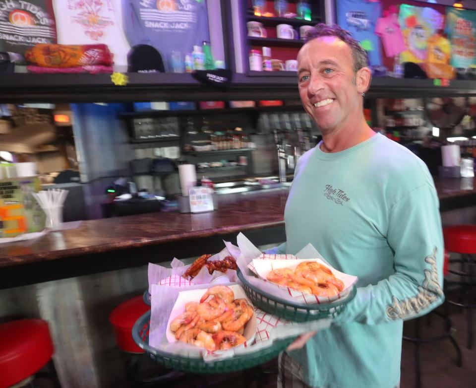 Another longtime employee at High Tides at Snack Jack heads to a table with an order of seafood on a recent afternoon in Flagler Beach. Chuck Ballassone started at the restaurant in 2005 and wears many hats, including head of maintenance. "I do a little bit of everything," he said.