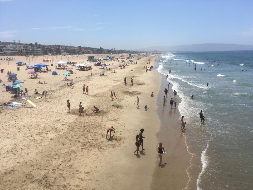 Visitantes en la playa de Manhattan Beach, California, el sábado 15 de agosto de 2020, en medio de una ola de calor que trajo temperaturas peligrosamente altas, un mayor peligro de incendios forestales y el temor a la propagación del coronavirus a medida que las personas acuden a las playas y parques en busca de alivio. (Foto AP/John Antczak)