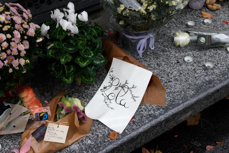 A photograph shows flowers displayed outside the middle school Georges Brassens in Paris on October 17, 2022, where a 12-year-old girl named Lola studied, three days after her body was discovered in a trunk.  / Credit: GEOFFROY VAN DER HASSELT/AFP via Getty Images