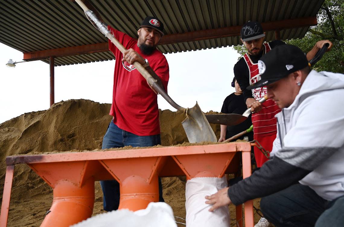 Gilbert Chavez, left, fills sandbags as Ray Ravera, right, holds them steady between rain showers at the Area 7 Road Yard located at 9400 N. Matus Thursday afternoon, Jan. 5, 2022 in Fresno. The County of Fresno is offering five sandbag locations: Biola, Sanger, Auberry, Caruthers and the Fresno/Clovis location on Matus.