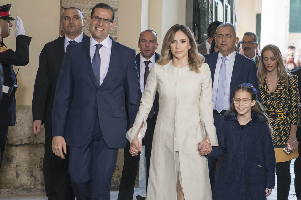 The new Prime Minister of Malta Robert Abela walks into the President office in Valletta for the swearing in ceremony, together with his wife Lydia Abela and his daughter Giorgia Mae, Monday, Jan. 13, 2020. Abela is replacing Joseph Muscat after weeks of protests demanding accountability in the investigation of the car bomb slaying of an anti-corruption journalist who targeted his government. (AP Photo/Rene' Rossignaud)