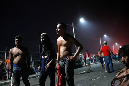 Members of a caravan of thousands of migrants from Central America en route to the U.S, rest after they clashed with the Mexican Police near the border gate, with the intention to carry on their journey, in Tecun Uman, Guatemala, October 28, 2018. REUTERS/Carlos Garcia Rawlins