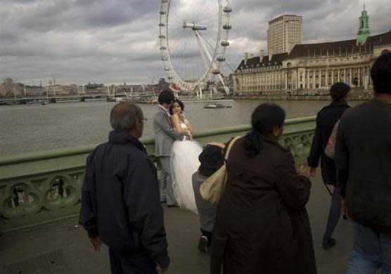 Newlyweds pose for photographs on Westminster Bridge in London March 10, 2012.