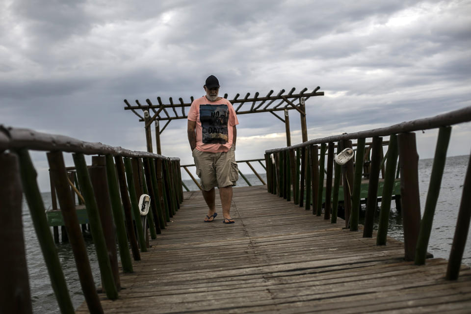 Gilson Silva do Carmo, an alleged victim of the G.A.S Consulting & Technology, a cryptocurrency investment firm, walks off after an interview in Iguaba Grande, Brazil, Wednesday, Dec. 15, 2021. Federal and state police and prosecutors accuse the firm of running a sophisticated racket defrauding thousands of small-scale investors who believed they were getting rich off bitcoin’s steep appreciation. Do Carmo watched in horror as the seizures and arrests unfolded; he had invested the rest of his savings in the company just weeks earlier. (AP Photo/Bruna Prado)