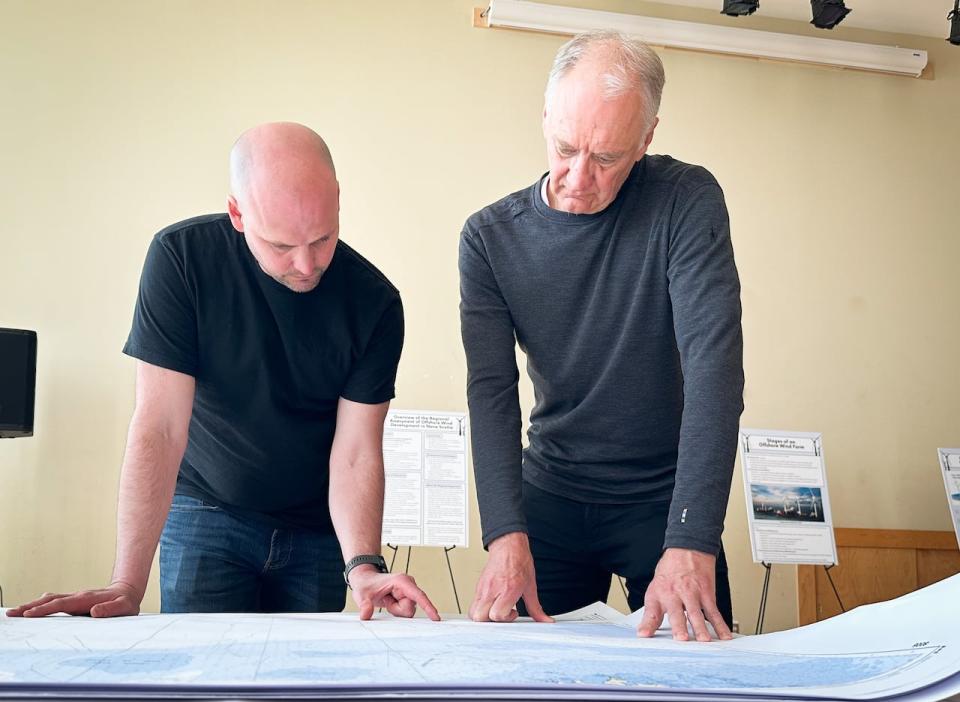 Committee worker Andy Walter and committee co-chair Jim Wooder go over maps of proposed offshore wind farm locations in Nova Scotia.