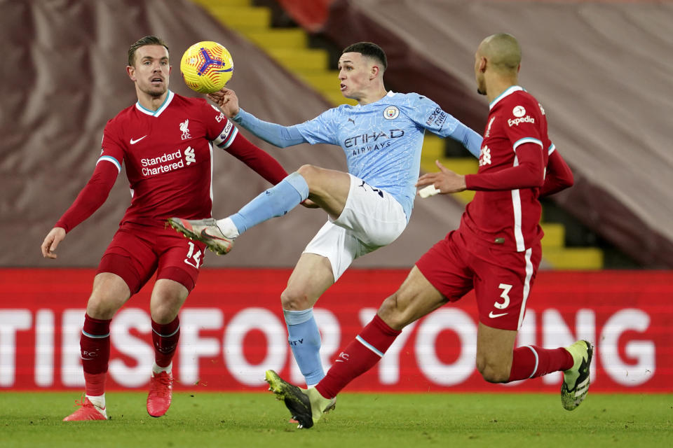Manchester City's Phil Foden controls the ball between Liverpool's Jordan Henderson, left, and Liverpool's Fabinho during the English Premier League soccer match between Liverpool and Manchester City at Anfield Stadium, Liverpool, England, Sunday, Feb. 7, 2021. (AP photo/Jon Super, Pool)