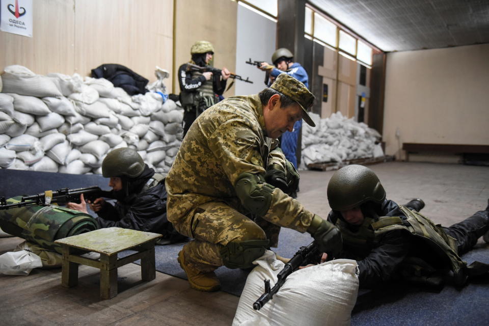 Several volunteers receive weapons training in a room. 