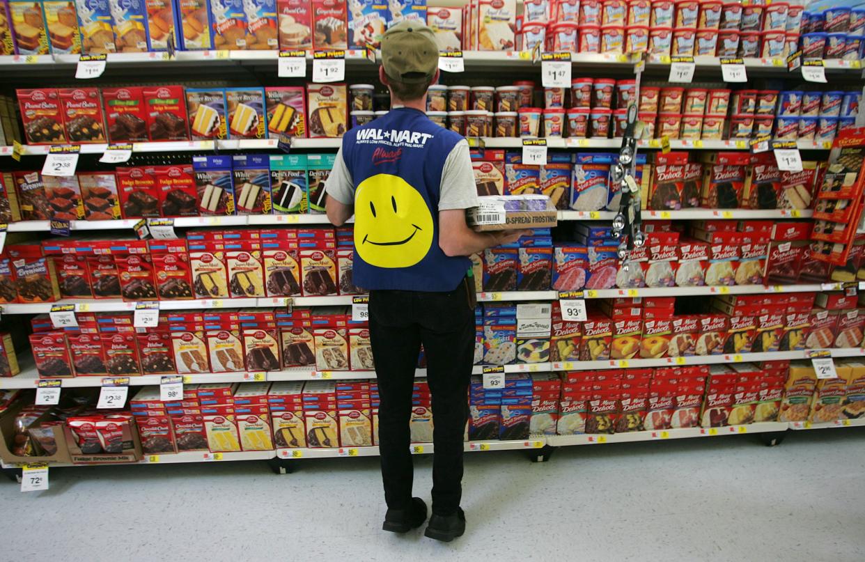 Walmart employee restocks a shelf in the grocery section of a Wal-Mart Supercenter in Troy, Ohio.