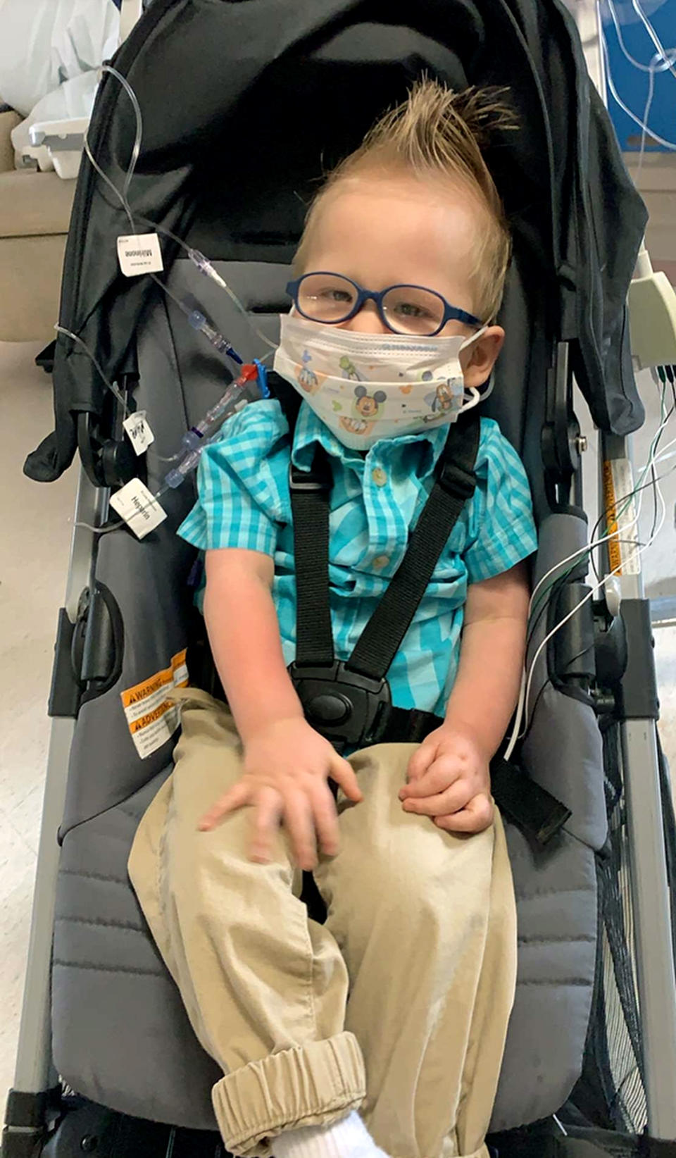 In this photo provided by Reeanne Parisien her son, Greyson, sits in a stroller at the Mayo Clinic in Rochester, Minn., in May 2019. Greyson's journey to correct a heart defect led the Turtle Mountain Band of Chippewa Indians to designate a spot on tribal IDs for organ donation. (Reeanne Parisien via AP)