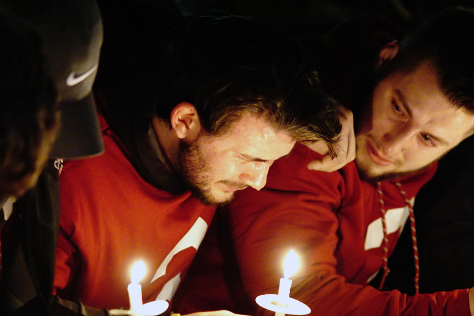 Luke Falk (left) cries during a candlelight memorial service for Tyler Hilinski. (AP)