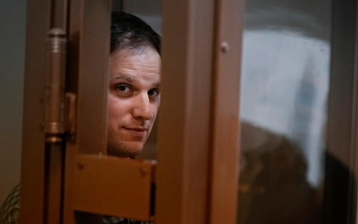 Wall Street Journal reporter Evan Gershkovich stands in a defendant's cage for a hearing in Moscow, Russia