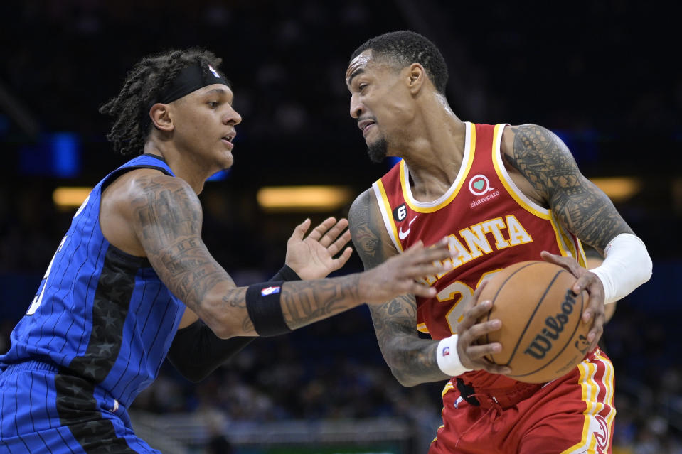 Atlanta Hawks forward John Collins, right, is defended by Orlando Magic forward Paolo Banchero (5) during the first half of an NBA basketball game Wednesday, Nov. 30, 2022, in Orlando, Fla. (AP Photo/Phelan M. Ebenhack)