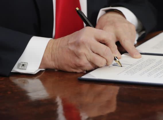 President Trump signs an executive order in the Oval Office of the White House in Washington on Feb. 3. (Photo: Pablo Martinez Monsivais/AP)