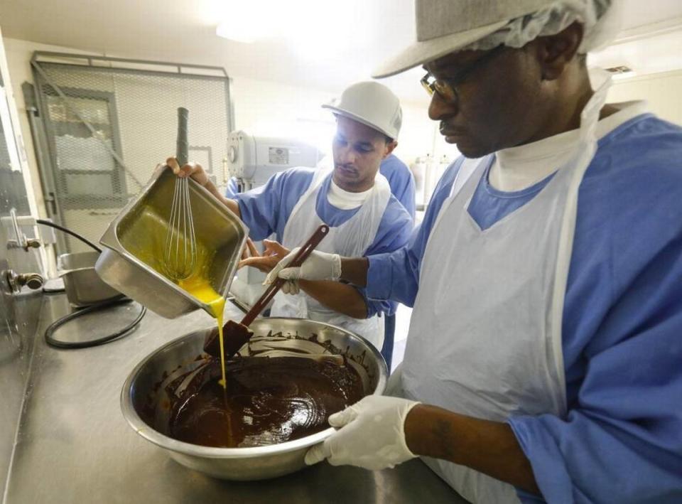 Sherman August, back, and Marc Collier prepare the batter for a flourless chocolate cake as part of the California Men’s Colony’s culinary arts program. David Middlecamp/dmiddlecamp@thetribunenews.com