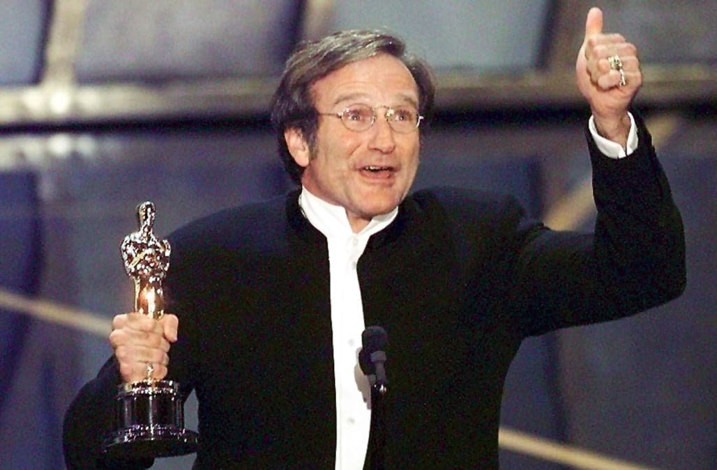 Actor Robin Williams holds up his Oscar after winn