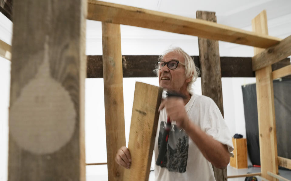 Lars Vilks, a Swedish artist, constructs an exhibit at the Ujazdowski Castle Center for Contemporary Art in Warsaw, Poland, Wednesday Aug. 25, 2021. The exhibition which opens Friday at the Polish state museum features the works of provocative artists in what organizers describe as a celebration of free speech, and a challenge to political correctness and "cancel culture" on the political left. Some critics, however, accuse the organizers of the show titled "Political Art" of giving a platform to anti-Semitic, racist and Islamophobic messages. Vilks lives under police protection for making a drawing of a dog with the head of the Prophet Muhammed. The drawing enraged many Muslims in 2007 and sparked death threats from extremists. (AP Photo/Czarek Sokolowski)