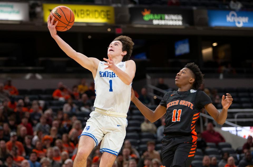 Marian's Deaglan Sullivan (1) drives in for a layup in front of Beech Grove's Jeremiah Tate (11) during the 3A boys basketball state championship game on Saturday, March 26, 2022, at Gainbridge Fieldhouse in Indianapolis. 