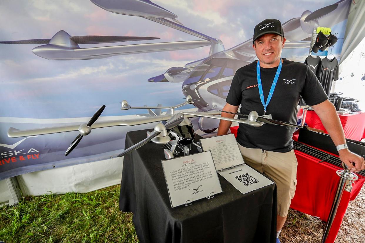 Guy Kaplinsky of Los Angeles poses during EAA AirVenture in Oshkosh with a model of an electric flying car that he developed.