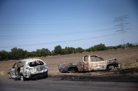 The wreckage of two cars that were burnt in a blockade set by members of the Santa Rosa de Lima Cartel to repel security forces during an anti-fuel theft operation are pictured in Santa Rosa de Lima, in Guanajuato state, Mexico, March 6, 2019. REUTERS/Edgard Garrido