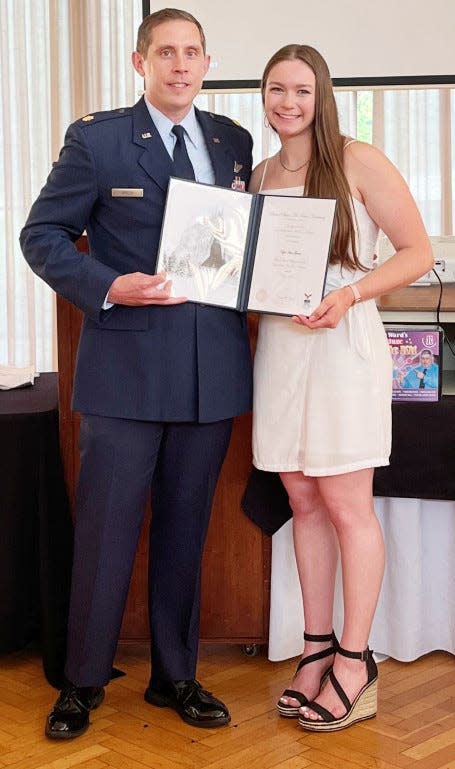 Maj. Tony Greco, left, representing the Air Force Academy, presents Bartlesville High School recent graduate Kylee Greene with her appointment to the venerable institution. Greene is slated to compete in gymnastics with the school.