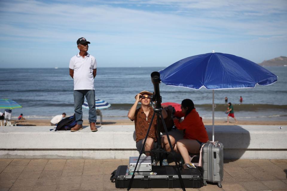 People prepare their telescope to see the eclipse in Mazatlan, Mexico.<span class="copyright">Hector Vivas—Getty Images</span>