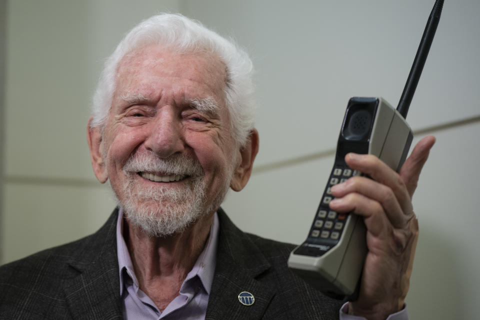 Marty Cooper, the inventor of first commercial mobile phone, poses for the press with a Motorola DynaTAC 8000x, during an interview with The Associated Press at the Mobile World Congress 2023 in Barcelona, Spain, Monday, Feb. 27, 2023. The four-day show kicks off Monday in a vast Barcelona conference center. It's the world's biggest and most influential meeting for the mobile tech industry. (AP Photo/Joan Mateu Parra)