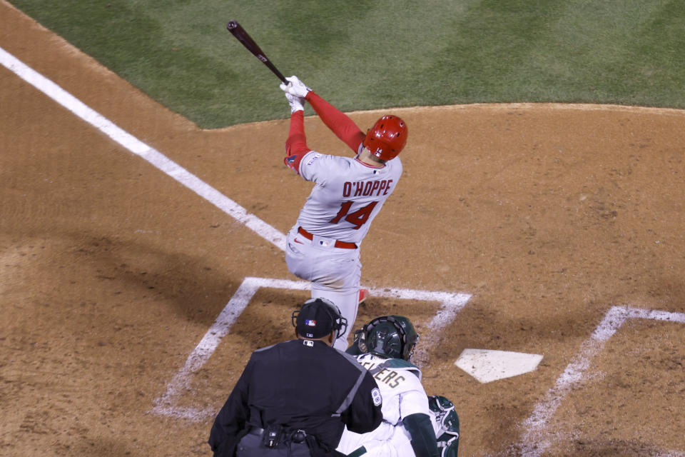 Los Angeles Angels' Logan O'Hoppe (14) hits an RBI-single in front of Oakland Athletics catcher Shea Langeliers, bottom right, in the fifth inning of an opening day baseball game in Oakland, Calif., Thursday, March 30, 2023. (AP Photo/Jed Jacobsohn)