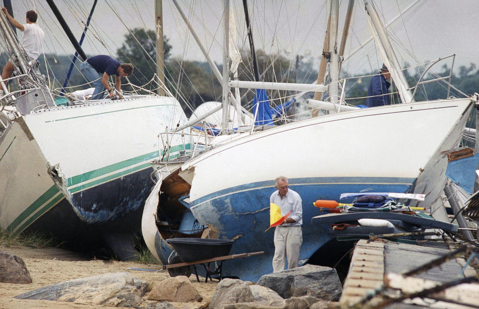 FILE - Boat owners gather their belongings along the shore in Dartmouth, Mass., Aug. 20, 1991, after Hurricane Bob swept through southern Massachusetts. New England is known for its fickle weather, powerful nor'easters and blizzards. Destructive hurricanes, however, are relatively rare and typically don't pack the same punch as tropical cyclones that hit the Southeast. Hurricanes usually lose some steam, becoming tropical storms, or extratropical storms, in northern waters. (AP Photo/Susan Walsh, File)