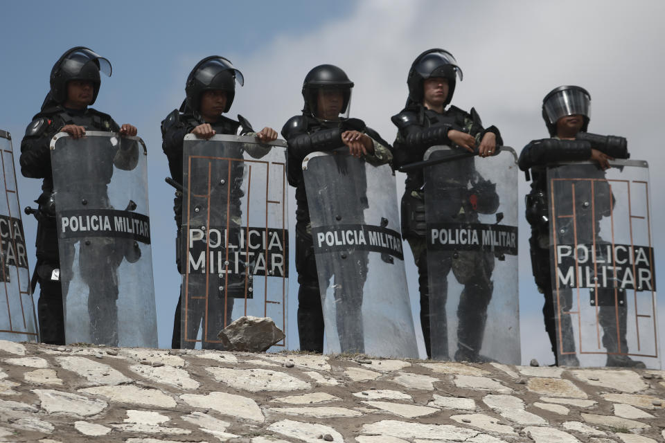 National Guard troops equipped with riot gear stand guard at Las Pilas dam, two days after withdrawing from the nearby Boquilla dam after clashing with hundreds of farmers, in Camargo, Chihuahua State, Mexico, Thursday, Sept. 10, 2020. President Andrés Manuel López Obrador said Thursday he regretted the killing of a woman and the wounding of her husband following a Tuesday clash between National Guard troops and farmers over water. (AP Photo Christian Chavez)