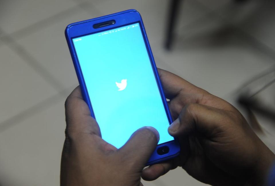 Indian man poses for a photograph using Twitter on his cellphone in Siliguri  (AFP via Getty Images)