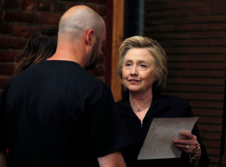 U.S. Democratic presidential candidate Hillary Clinton speaks to Bo Copley about a photograph of his children during a campaign event in Williamson, West Virginia, United States, May 2, 2016. REUTERS/Jim Young