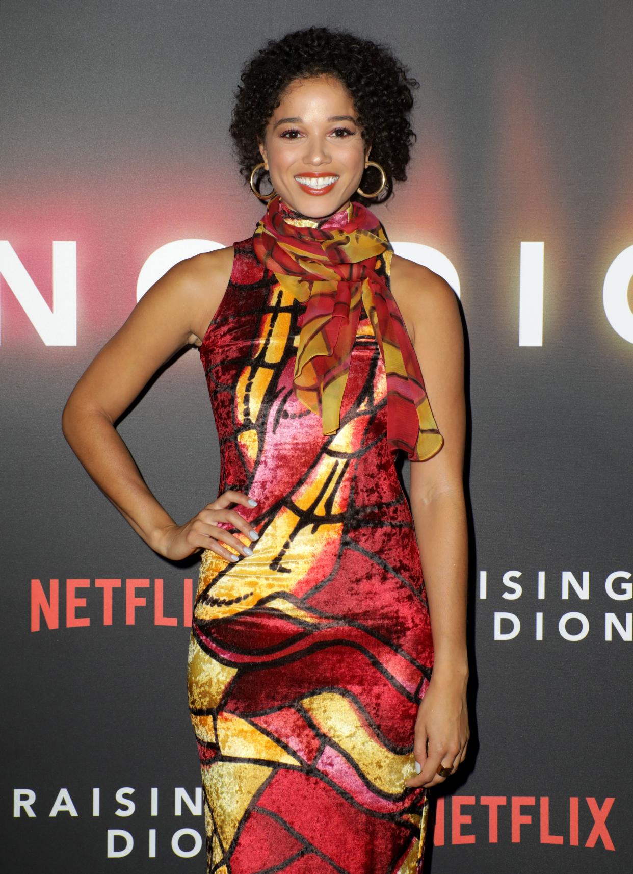 Alisha Wainwright poses with one hand on her hip at the Raising Dion premiere