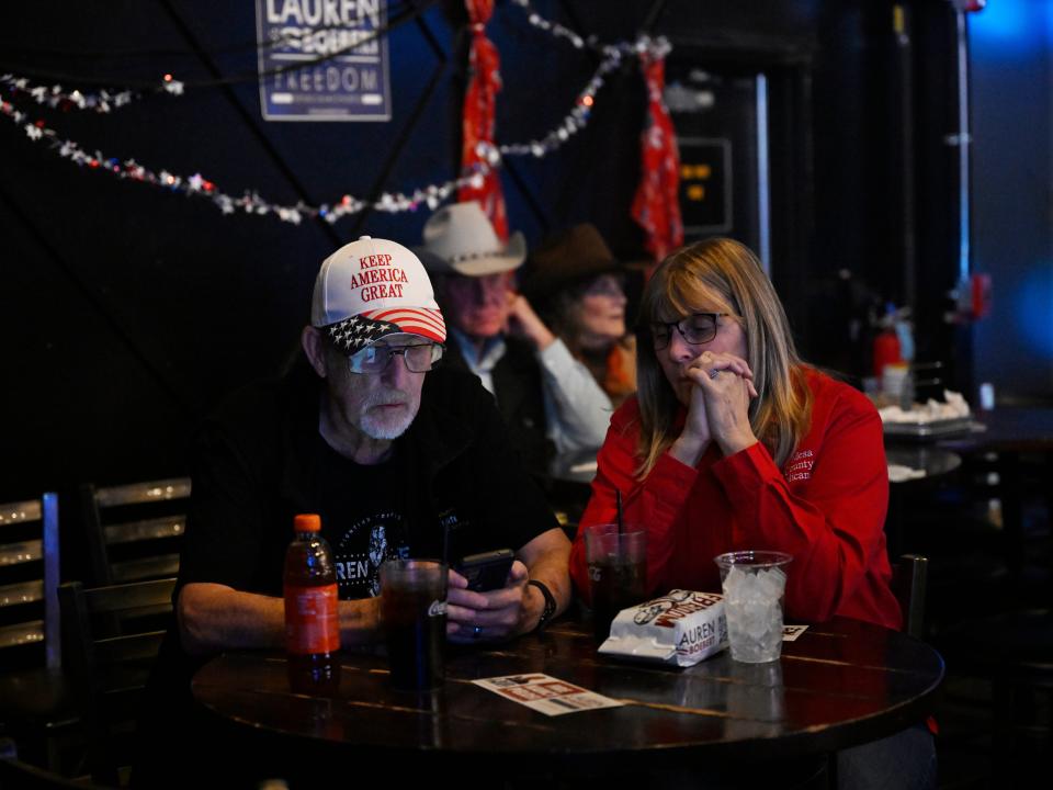 Dale and Sherri VanPelt check their phone for election results during a party for Republican Congresswoman Lauren Boebert on Election night at Warehouse 2565 on November 8, 2022 in Grand Junction, Colorado. Boebert is running against Adam Frisch of the Democratic Party to try for her second term as U.S. representative for Colorado's 3rd congressional district.