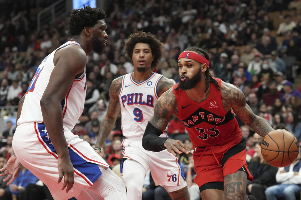 Toronto Raptors' Gary Trent Jr. drives against Philadelphia 76ers' Joel Embiid during the first half of an NBA basketball game Saturday, Oct. 28, 2023, in Toronto. (Chris Young/The Canadian Press via AP)