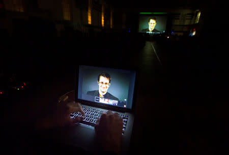 FILE PHOTO: A student works on a computer that is projecting former U.S. National Security Agency contractor Edward Snowden as he appears live via video during a student-organized world affairs conference at the Upper Canada College private high school in Toronto, Canada February 2, 2015. REUTERS/Mark Blinch/File Photo