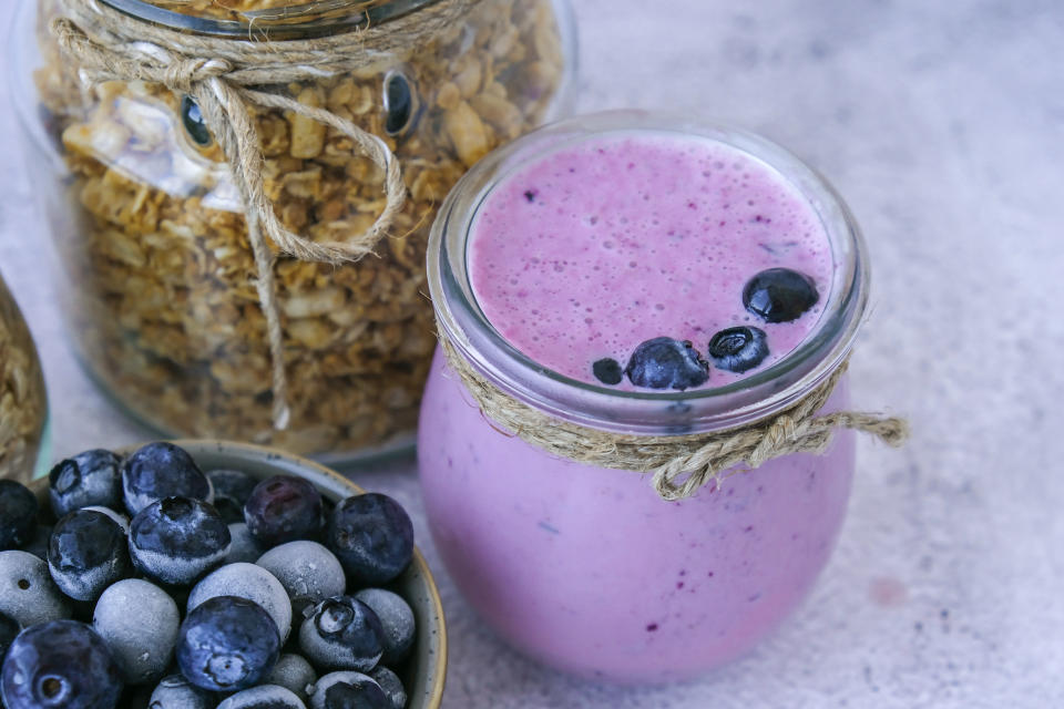 Blueberry smoothie topped with blueberries. A glass of breakfast protein smoothie drink made from pureed raw blueberries, banana, milk, yogurt, and cottage cheese. Vegetarian vegan food