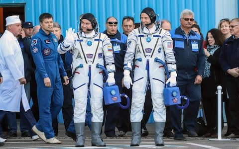 Alexei Ovchinin and Nick Hague wave to onlookers before boarding the spacecraft - Credit: Sergei Savostyanov/TASS/Barcroft