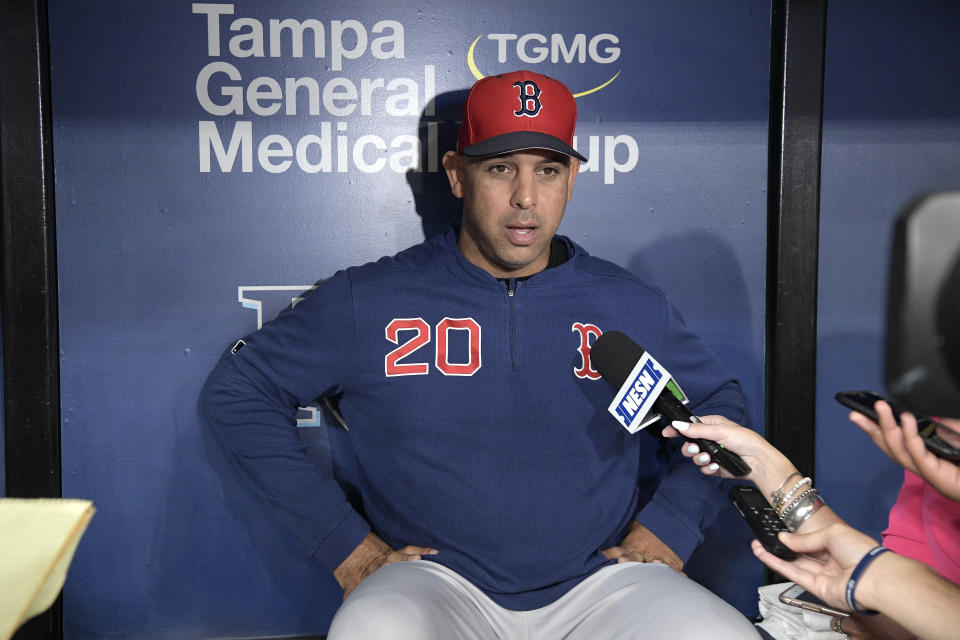 Boston Red Sox manager Alex Cora (20) answers questions from reporters in the dugout before a baseball game against the Tampa Bay Rays Friday, Sept. 20, 2019, in St. Petersburg, Fla. (AP Photo/Phelan M. Ebenhack)