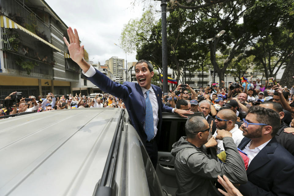 Juan Guaido, opposition leader and self-proclaimed interim president of Venezuela, greets supporters as he leaves Plaza Bolivar after an outdoor, town hall-style meeting in the Chacao area of Caracas, Venezuela, Friday, April 19, 2019. The opposition held the forum to announce a new strategy against the government of President Nicolas Maduro. (AP Photo/Fernando Llano)