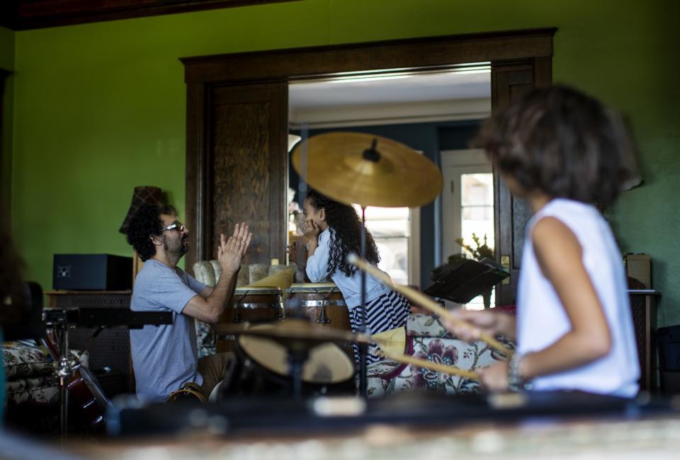 Gabe Roth teaches rhythm to Allison Furbush while his son Sylvester Roth keeps the beat on the drums during music class.