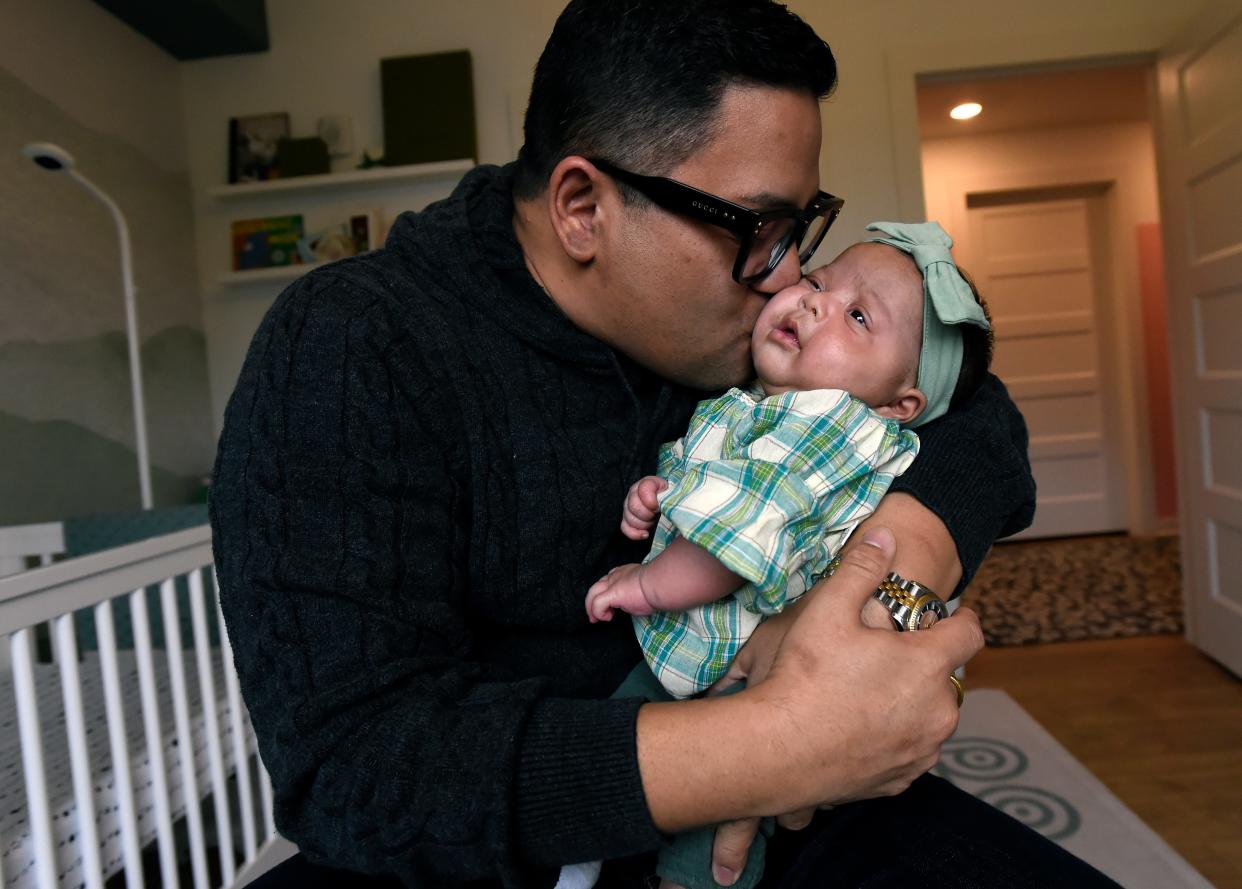 Renowned Nashville Chef Arnold Myint cuddles his daughter, Henley, on Tuesday, Nov. 21, 2023, in Nashville, Tenn. Myint, who had Henley through surrogacy, discusses being a single, gay dad in Tennessee.