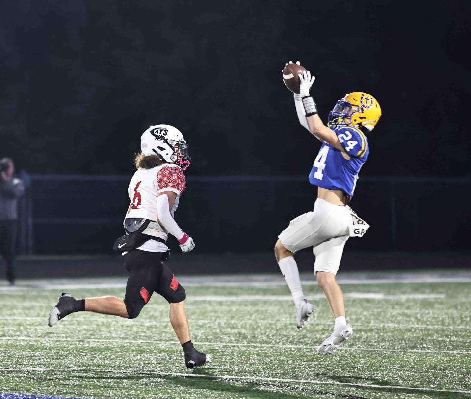 Newport Central Catholic defensive back Mitchell Doeker (24) intercepts a pass intended for Newport wide receiver Landon Stacks (6) during their 22-6 win Friday, Oct. 6, 2023.