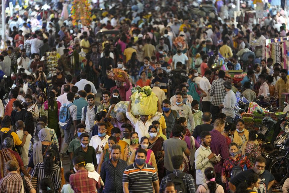 FILE - People crowd a market area outside a train station in Mumbai, India, Saturday, March 12, 2022. Demographers are unsure exactly when India will take the title as the most populous nation in the world because they're relying on estimates to make their best guess. (AP Photo/Rajanish Kakade, File)