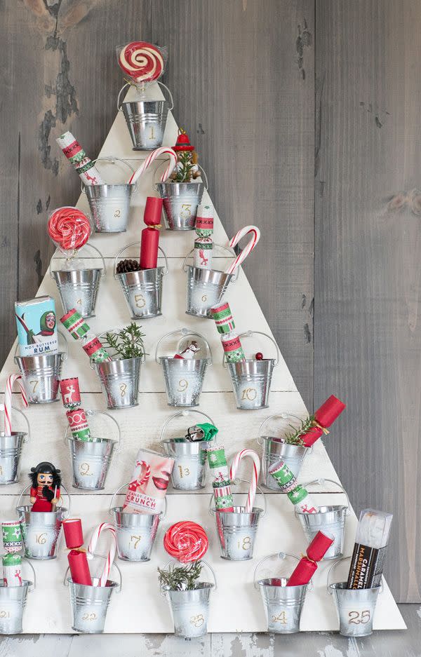 <p>Here's another great DIY advent calendar brought to us by <a href="https://sugarandcharm.com/diy-wooden-advent-calender" rel="nofollow noopener" target="_blank" data-ylk="slk:Sugar and Charm;elm:context_link;itc:0;sec:content-canvas" class="link ">Sugar and Charm</a>. You'll just need some plywood, small tin cans, and a hot glue gun (and then goodies, of course). </p>