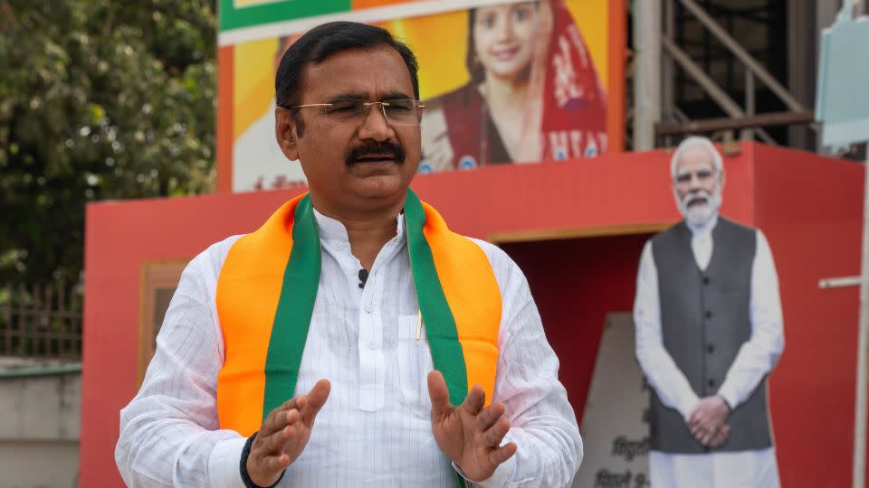 Varanasi BJP President Dileep Patel at his office, in front of a Modi cutout. - John Mees/CNN