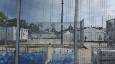 FILE PHOTO: Detainees walk around the compound near a stack of water bottles inside the Manus Island detention centre in Papua New Guinea, February 11, 2017. Behrouz Boochani/Handout via REUTERS/File Photo