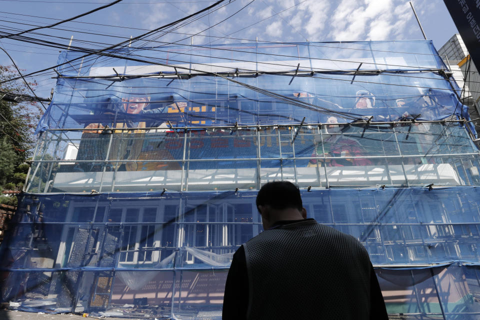 A man stands near the North Korea-themed restaurant under construction in Seoul, South Korea, Monday, Sept. 16, 2019. North Korea-themed restaurant in Seoul removes Kim portrait and flag image as police look into whether owner violated security law. (AP Photo/Lee Jin-man)